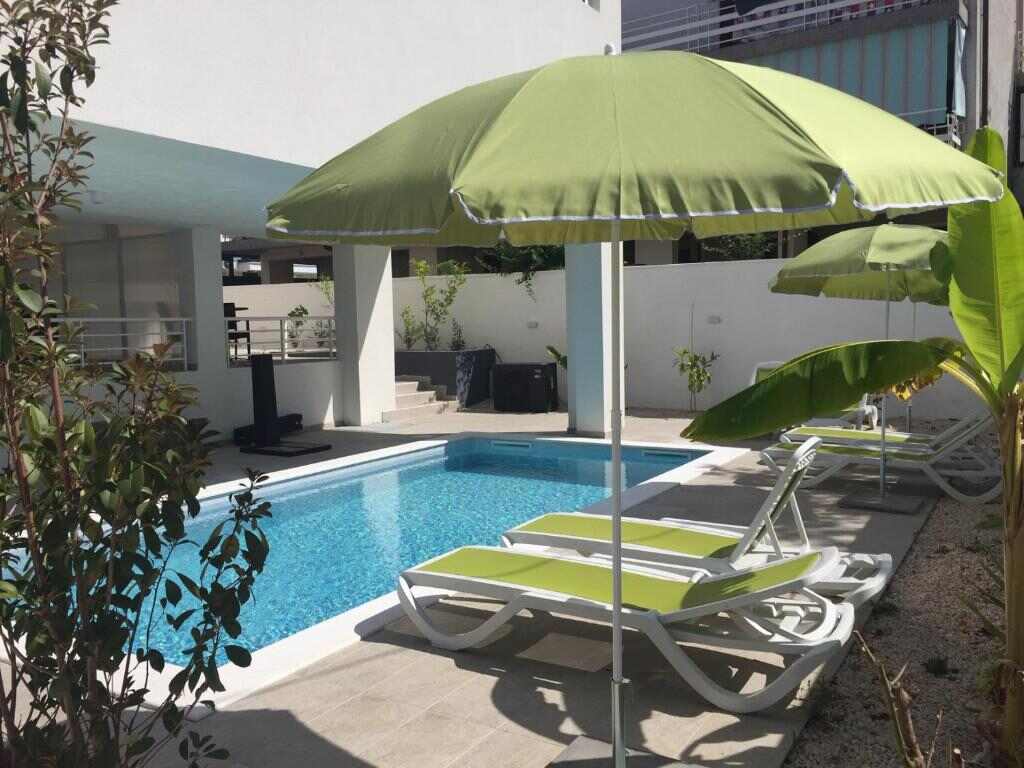 Pool with sun loungers and umbrellas